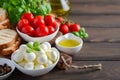 Italian food ingredients Ã¢â¬â mozzarella, tomatoes, basil and olive oil on rustic wooden table. Royalty Free Stock Photo